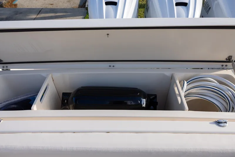 Slide: The Image of 2024 Grady-White Freedom 375 boat storage compartment with organized equipment and hoses. - 11