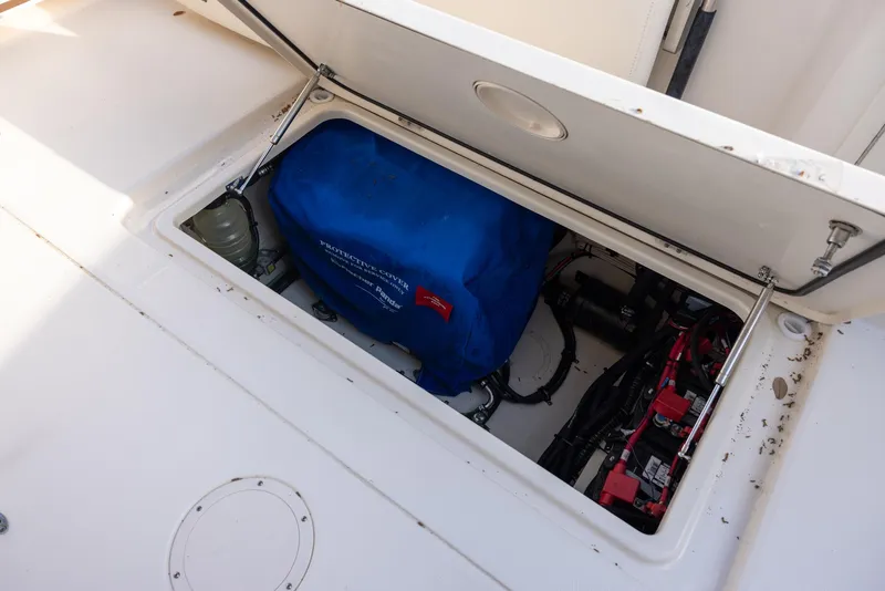 Slide: The Image of 2024 Grady-White Freedom 375 boat storage compartment with blue cover and wiring. - 14