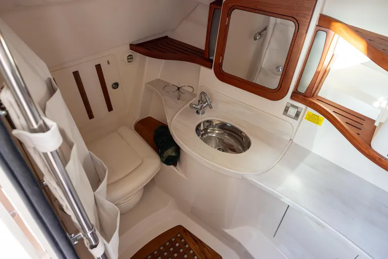 Slide: The Image of 2024 Grady-White Freedom 375 boat bathroom with sink, toilet, and wooden accents. - 22