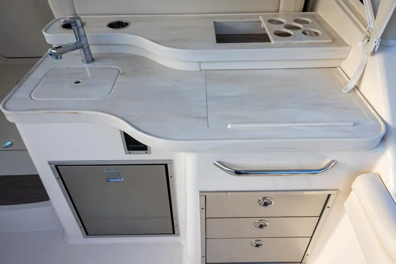 Slide: The Image of 2024 Grady-White Freedom 375 boat kitchenette with sink, storage drawers, and cup holders. - 7