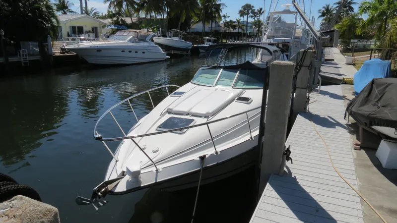Slide: The Image of 1998 Doral 300 SC V Drive boat docked in a sunny marina. - 13