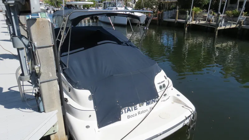 Slide: The Image of 1998 Doral 300 SC V Drive boat docked in a marina, covered with a dark canopy. - 14