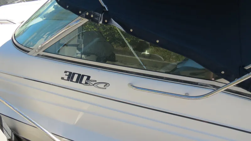 Slide: The Image of 1998 Doral 300 SC V Drive boat with blue canopy and sleek design. - 15