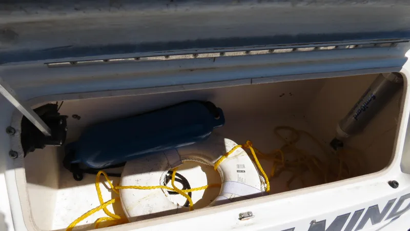 Slide: The Image of Open storage compartment on 1998 Doral 300 SC V Drive boat with life preserver and rope. - 29