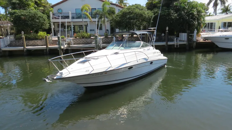 Slide: The Image of 1998 Doral 300 SC V Drive boat docked on a calm waterway. - 3