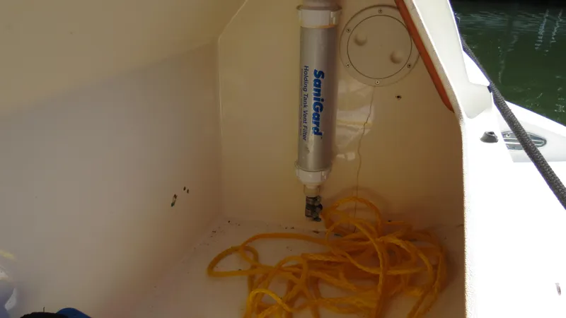 Slide: The Image of 1998 Doral 300 SC V Drive boat interior with yellow hose and water filter system. - 30