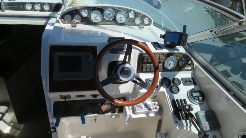 Slide: The Image of 1998 Doral 300 SC V Drive boat dashboard with gauges and wooden steering wheel. - 31