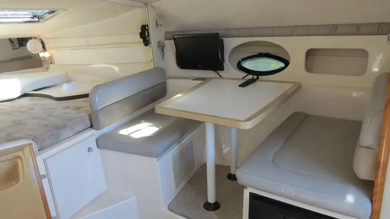 Slide: The Image of 1998 Doral 300 SC V Drive cabin interior with seating, table, and small TV. - 44