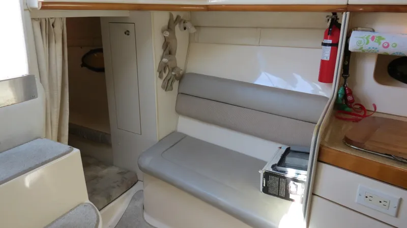 Slide: The Image of 1998 Doral 300 SC V Drive cabin interior with seating, fire extinguisher, and storage. - 47
