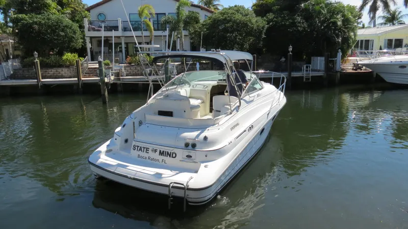 Slide: The Image of 1998 Doral 300 SC V Drive boat docked in a serene waterfront setting. - 8