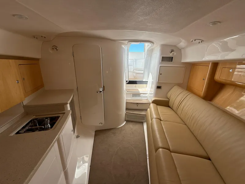 Slide: The Image of Interior of 2013 Intrepid 390 Sport Yacht with beige leather seating and compact kitchenette. - 21