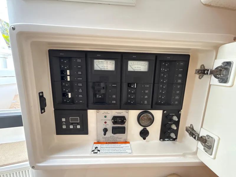 Slide: The Image of Electrical control panel of a 2013 Intrepid 390 Sport Yacht, featuring various switches and gauges. - 24