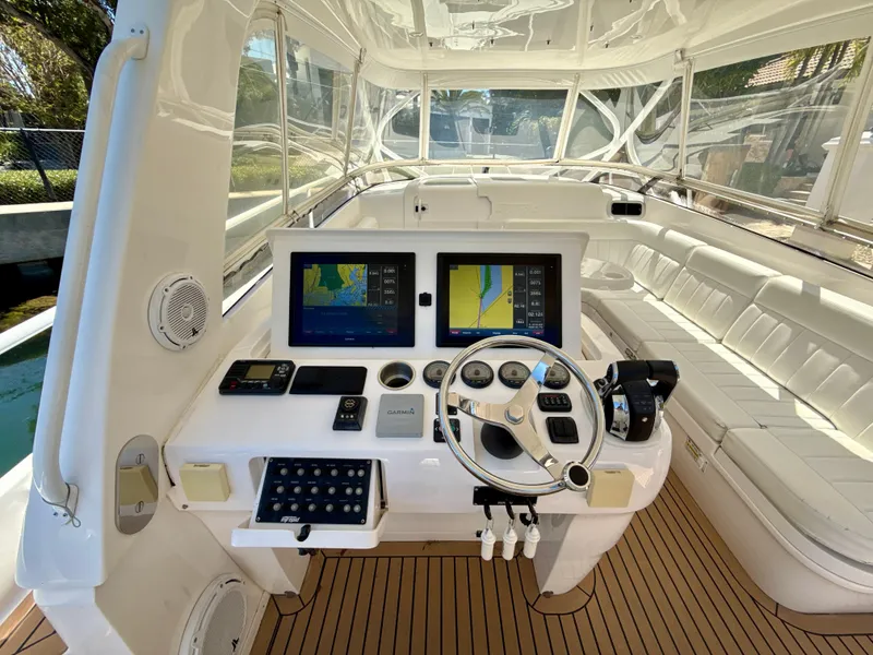 Slide: The Image of 2013 Intrepid 390 Sport Yacht cockpit with navigation screens and white seating. - 9