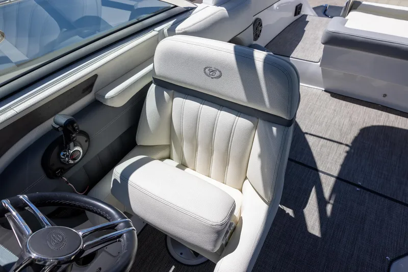 Slide: The Image of 2019 Cobalt 25SC boat interior with plush captain's chair and steering wheel. - 11