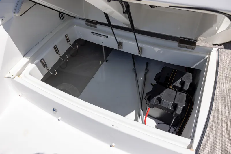 Slide: The Image of Open storage compartment of 2019 Cobalt 25SC boat, showing battery and wiring. - 17