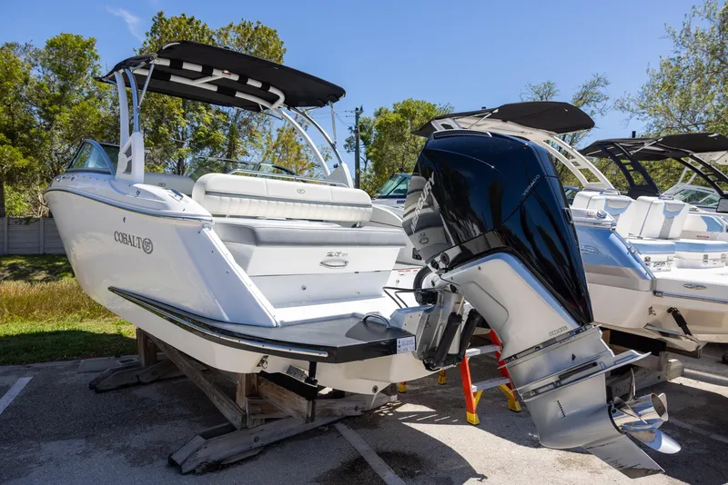 Slide: The Image of 2019 Cobalt 25SC boat with outboard motor on display in a sunny outdoor setting. - 4
