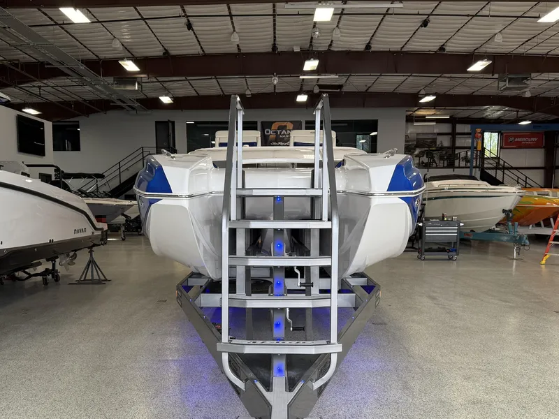 Slide: The Image of 2008 Magic 30' Sceptor boat in showroom with blue accents and metal stairs. - 16