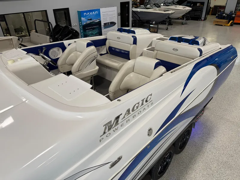 Slide: The Image of 2008 Magic 30' Sceptor powerboat with white and blue interior, showcased in a showroom. - 27