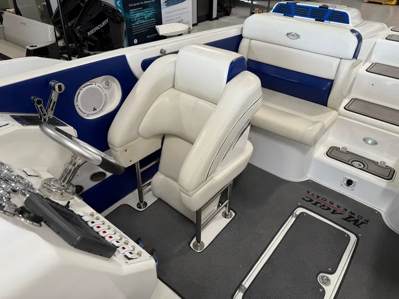 Slide: The Image of 2008 Magic 30' Sceptor boat interior with white and blue seating, steering wheel, and control panel. - 28