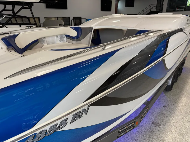 Slide: The Image of 2008 Magic 30' Sceptor boat with blue and white design in showroom. - 3