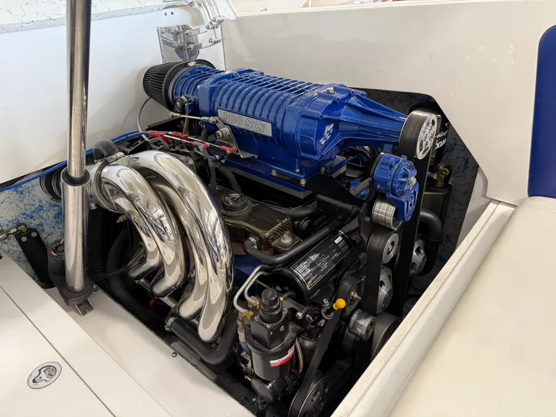 Slide: The Image of Engine of 2008 Magic 30' Sceptor boat with blue supercharger and chrome exhaust. - 36
