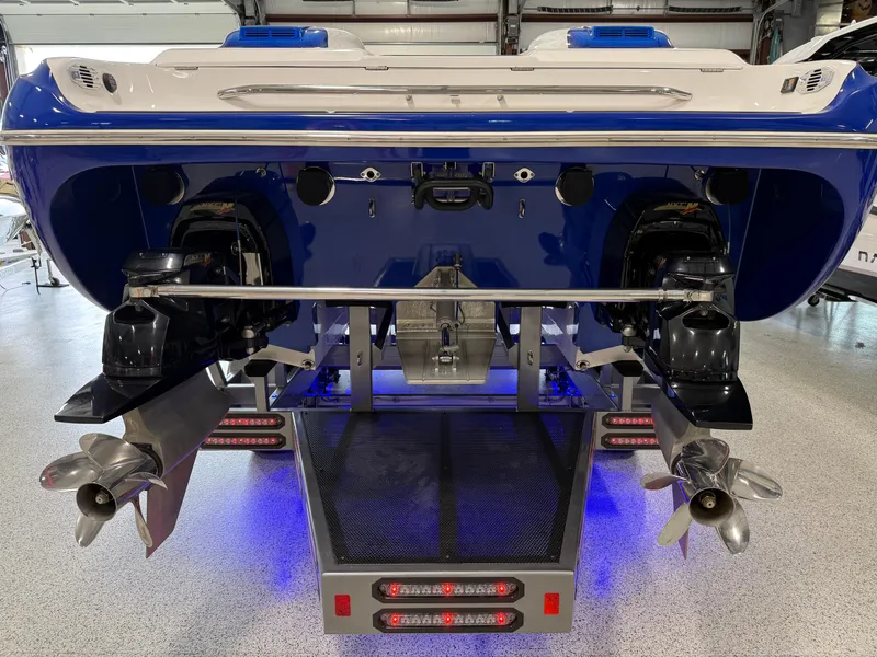 Slide: The Image of Rear view of 2008 Magic 30' Sceptor boat with dual propellers and blue lighting. - 38