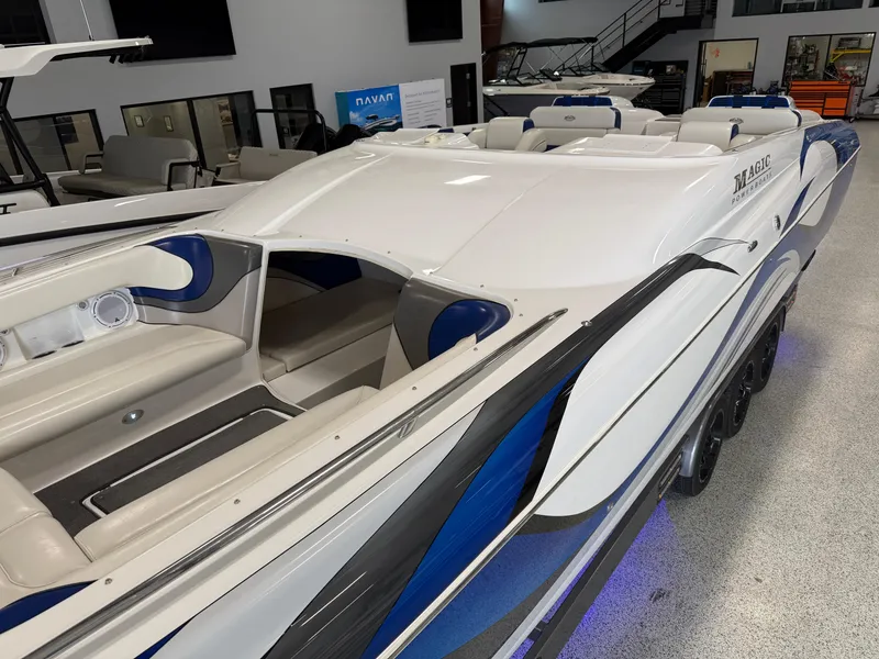 Slide: The Image of 2008 Magic 30' Sceptor boat with sleek design and blue accents in showroom. - 4