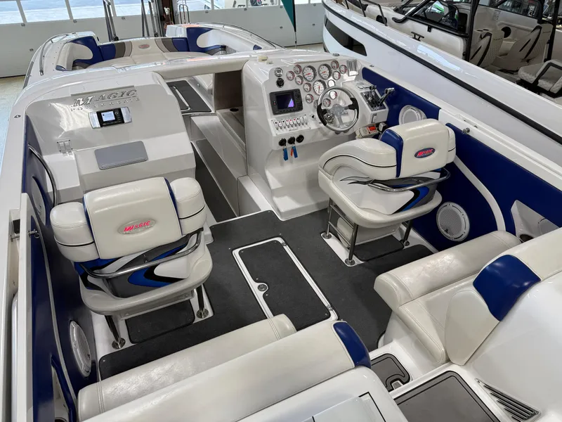 Slide: The Image of 2008 Magic 30' Sceptor boat interior with white and blue seating, modern dashboard, and spacious layout. - 44