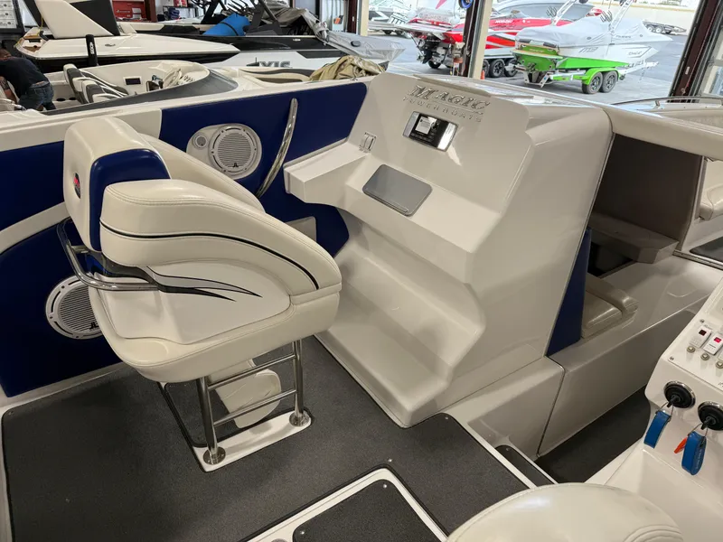 Slide: The Image of 2008 Magic 30' Sceptor boat interior with white and blue seating and control panel. - 48