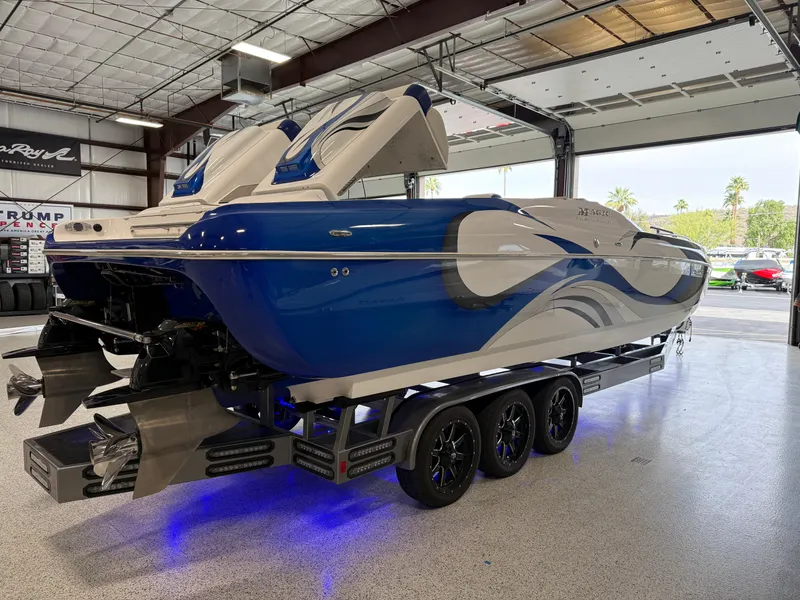Slide: The Image of 2008 Magic 30' Sceptor boat in a garage, featuring a sleek blue and white design. - 11