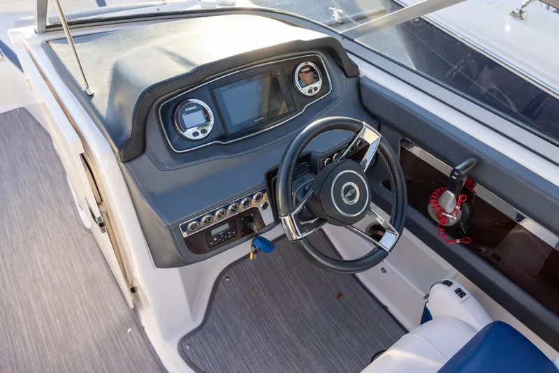Slide: The Image of 2020 Chaparral 230 Suncoast boat dashboard with steering wheel and control panel. - 10