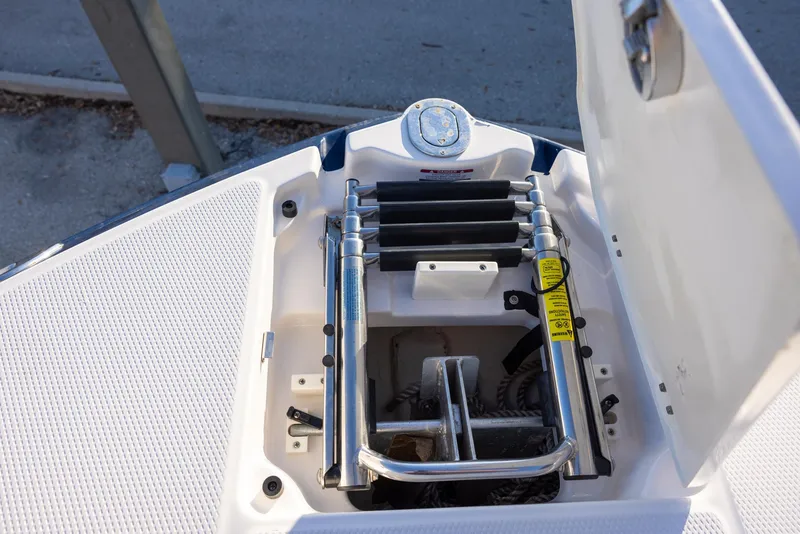 Slide: The Image of 2020 Chaparral 230 Suncoast boat ladder compartment with open hatch and stainless steel ladder. - 13