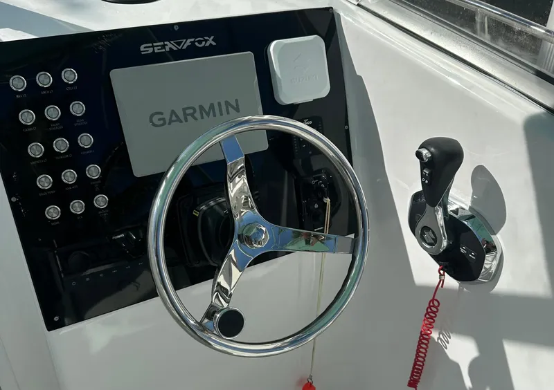 Slide: The Image of 2005 Sea Fox 257 Walk Around boat dashboard with Garmin navigation and steering wheel. - 14