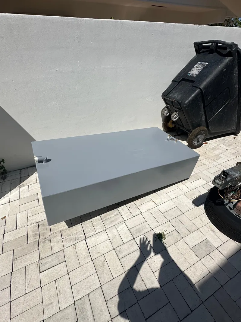 Slide: The Image of Gray metal box on paved ground near a black object, casting shadows. - 20