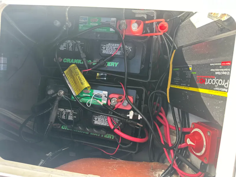 Slide: The Image of Battery compartment of a 2005 Sea Fox 257 Walk Around boat with wiring and connections. - 21