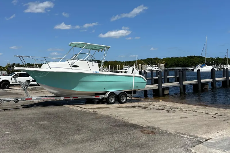 Slide: The Image of 2005 Sea Fox 257 Walk Around boat on trailer at marina under clear blue sky. - 22