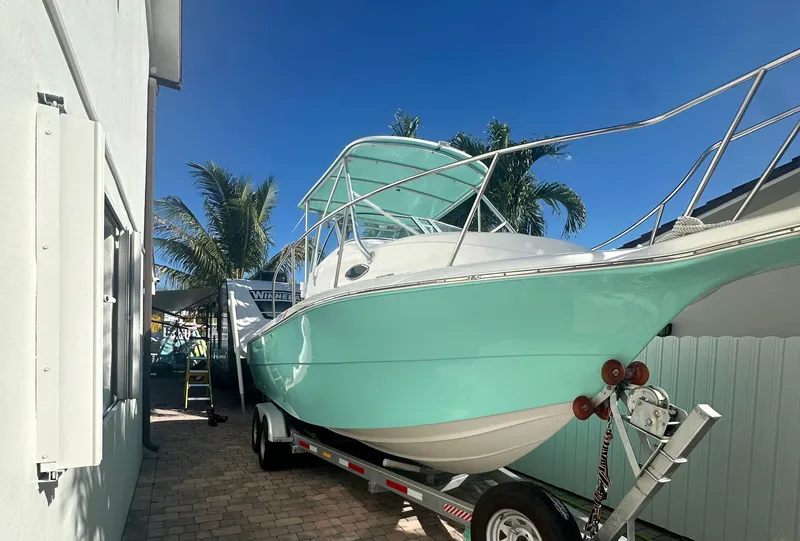 Slide: The Image of 2005 Sea Fox 257 Walk Around boat on trailer, parked near palm trees. - 5