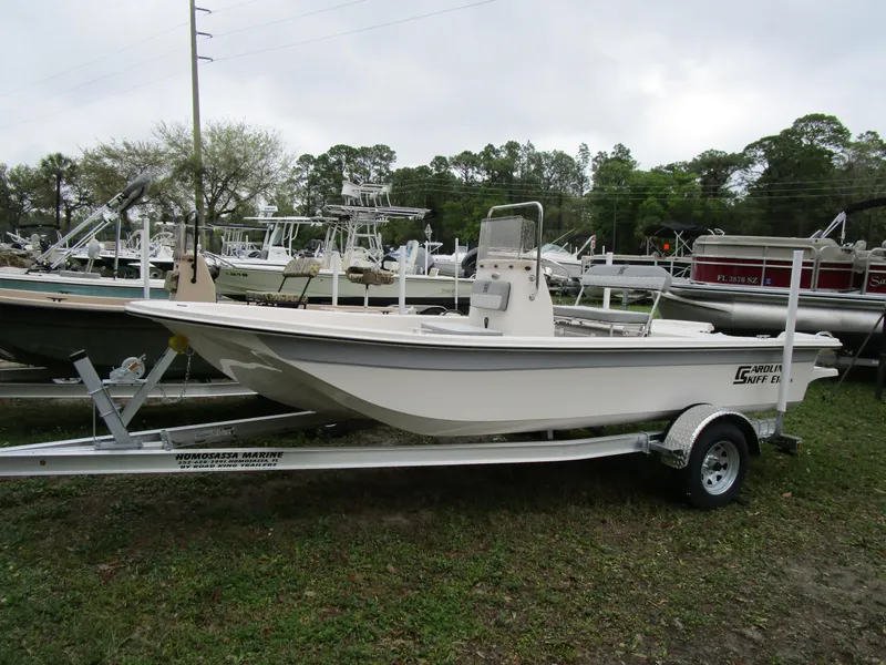 Slide: The Image of 2025 Carolina Skiff E Series E18 JVX CC boat on trailer, parked outdoors. - 2