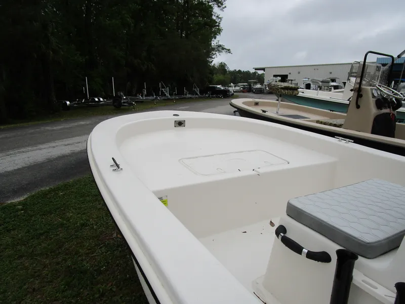 Slide: The Image of 2025 Carolina Skiff E Series E18 JVX CC boat, white deck, outdoor setting. - 4