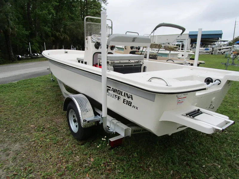 Slide: The Image of 2025 Carolina Skiff E Series E18 JVX CC boat on trailer, parked outdoors. - 7