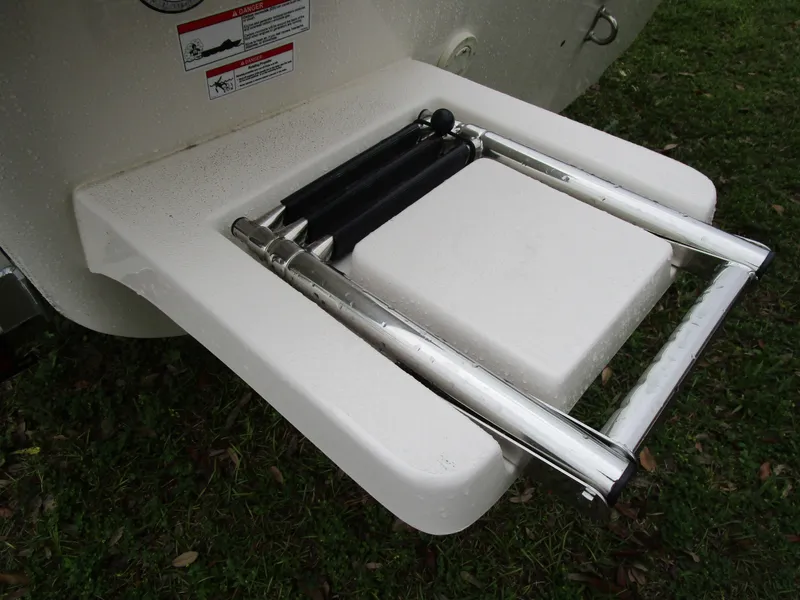 Slide: The Image of 2025 Carolina Skiff E Series E18 JVX CC boat ladder on grass. - 8