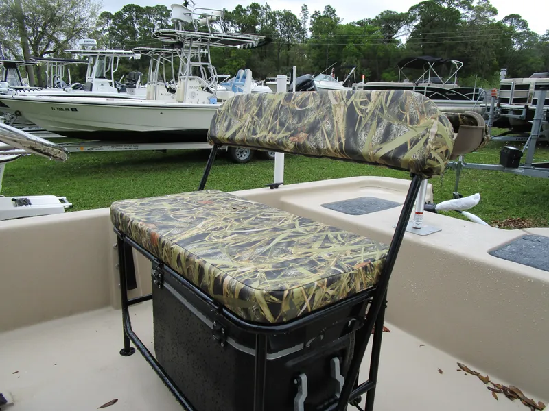 Slide: The Image of 2025 Carolina Skiff E Series E18 JVX CC boat with camo seating, parked outdoors. - 3
