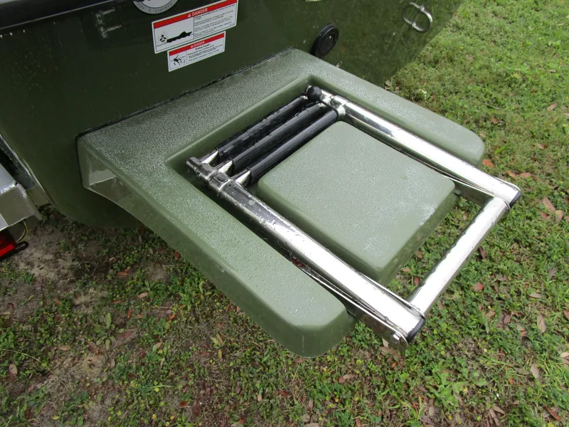 Slide: The Image of 2025 Carolina Skiff E Series E18 JVX CC boat ladder on grassy surface. - 8
