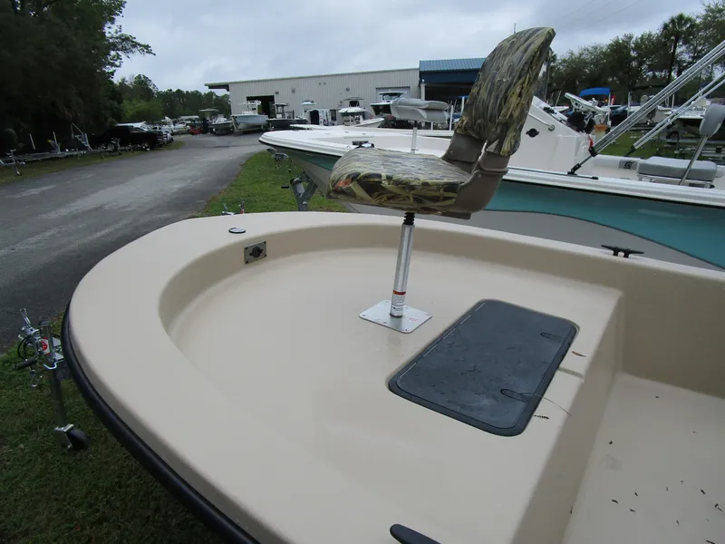 Slide: The Image of 2025 Carolina Skiff E Series E18 JVX CC boat with camo seat, parked outdoors. - 9