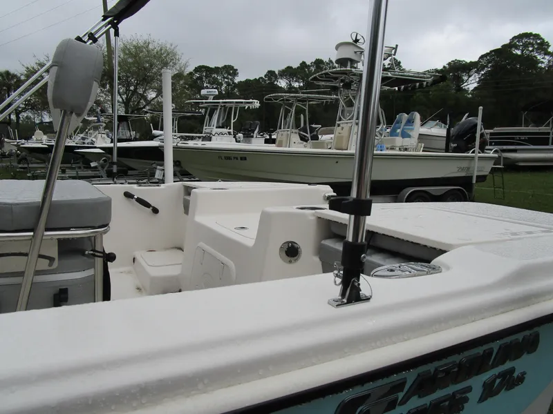 Slide: The Image of 2025 Carolina Skiff LS Series 17LS boat in a marina, surrounded by other vessels. - 10
