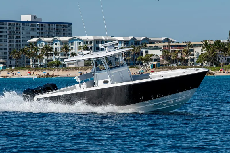 Slide: The Image of 2017 Contender 39 ST boat cruising on blue water near coastal buildings. - 25
