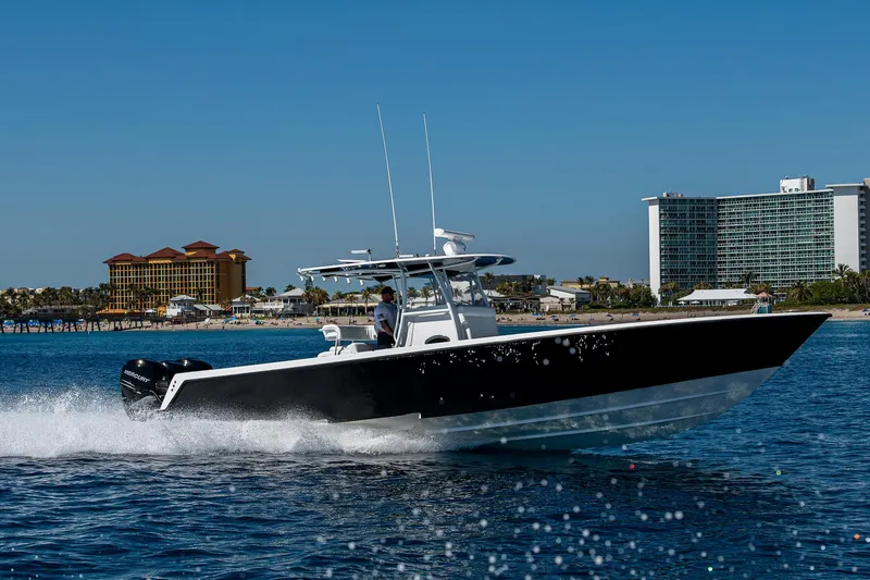 Slide: The Image of 2017 Contender 39 ST boat cruising on open water near coastal buildings. - 31
