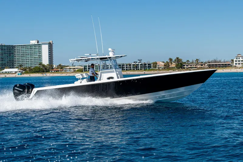 Slide: The Image of 2017 Contender 39 ST boat cruising on blue ocean near coastal buildings. - 32