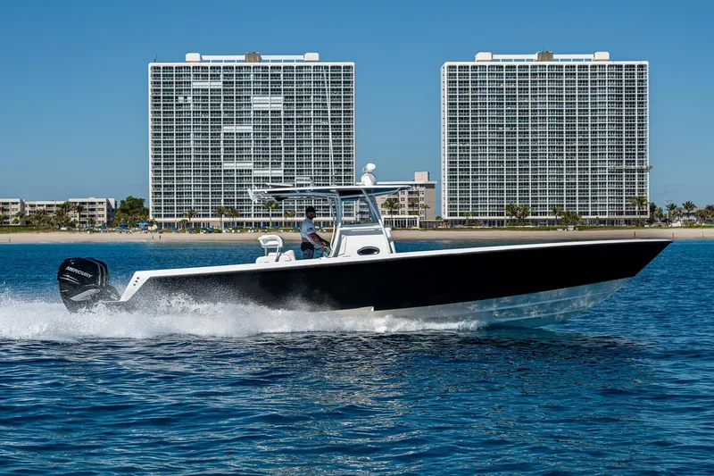 Slide: The Image of 2017 Contender 39 ST boat cruising on water with cityscape backdrop. - 33