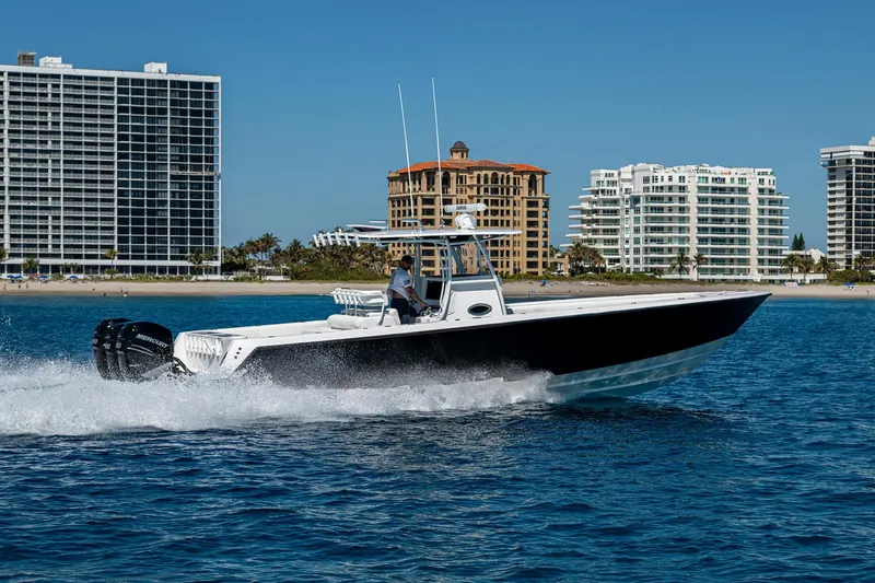 Slide: The Image of 2017 Contender 39 ST boat cruising on water near coastal buildings. - 34